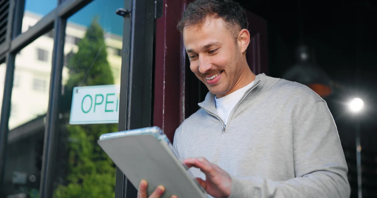 Small business owner reviewing benefits on tablet